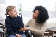 Child in wheelchair and therapist