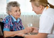 Caregiver assisting elderly woman